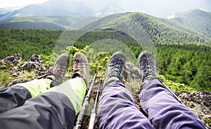 Hiker boots and legs resting on the mountain peak