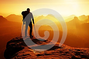 Hiker with broken leg in immobilizer. Deep misty valley bellow silhouette