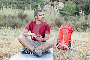 Hiker camping and using mobile.