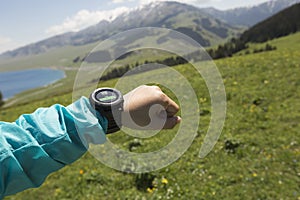 Hiker checking the altimeter on sports watch at mountain peak