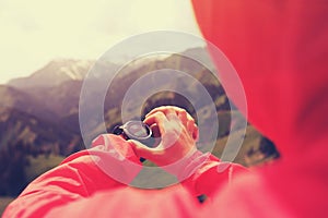 Hiker checking the altimeter on sports watch at mountain peak