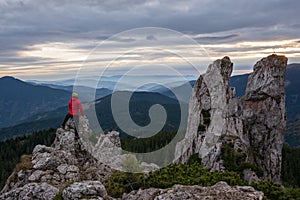 Hiker climbing high mountain rocks