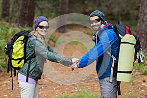 Hiker couple holding hands in forest