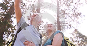 Hiker couple standing and pointing away in forest