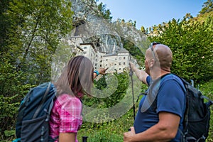 Hiker couple visiting the Predjama Castle inside the Postojna Cave in Slovenia
