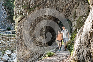 Hiker couple walking on the rocks while crossing mountain river