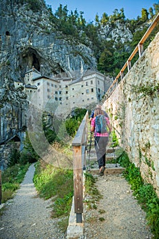 Hiker couple walking towards the at the Predjama Castle inside the Postojna Cave in Slovenia