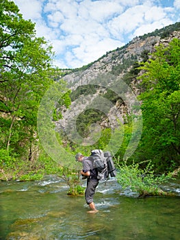 Hiker crosses a river