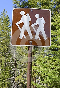 Hiker crossing sign in the mountains