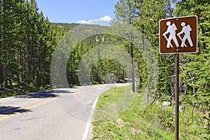 Hiker crossing sign in the mountains