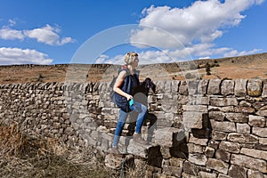 A hiker crossing a stile on the stone