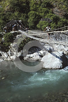 Hiker crossing suspension bridge