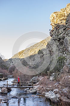 Hiker crossing wooden bridge at National Park of Cabaneros photo