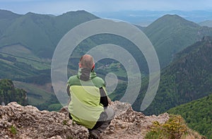 Turista s dredmi na malom rozsutci, na pozadí horskej dediny, malá fatra, slovensko v jarnom zamračenom ráne