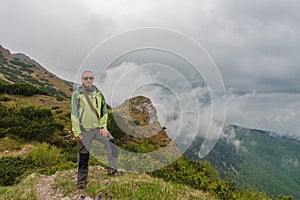 Hiker with dreadlocks on mountain pass Bublen, Mala Fatra, Slovakia, in spring cloudy day