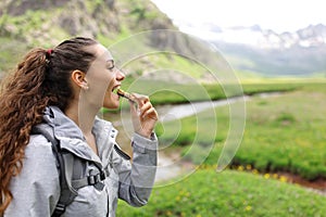 Hiker eating cereal bar in a valley photo