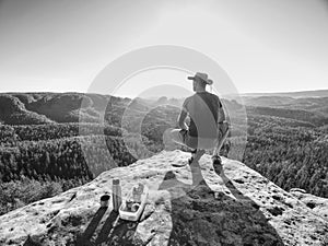 Hiker enjoy Refreshment. Tourist staying on top of Rock