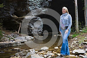 Hiker Enjoying the Beauty of a Cave and Creek