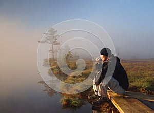 Hiker enjoying a morning coffee in a marsh