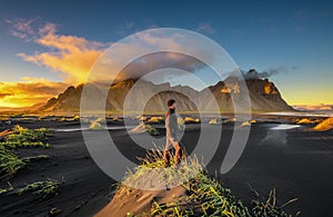 Hiker enjoying sunset at Vestrahorn and its black sand beach in Iceland photo