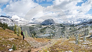 Hiker enjoying view on beautiful alpine valley with fresh snow, Mt Assiniboine Pr Park, Canada