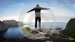 Hiker enjoying the view over Reinefjorden, Lofoten, Norway