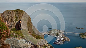 Hiker enjoying the view over Reinefjorden, Lofoten, Norway