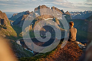 Hiker enjoying the view over Reinefjorden, Lofoten, Norway