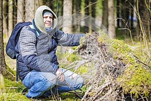 Hiker at the fallen tree roots in forest