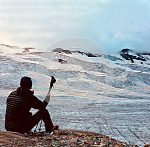 Hiker in front of a great alpine glacier. Back view. Italian Alp