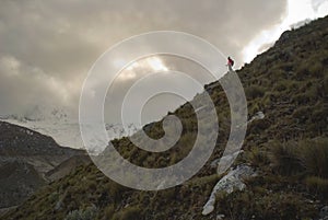 Hiker gazing at the glacier in the glacial valley in the desolate peruvian mountain landscape