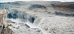 Hiker at gigantic Dettifoss waterfall in Iceland