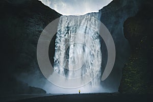 Hiker at gigantic Skogafoss waterfall in Iceland