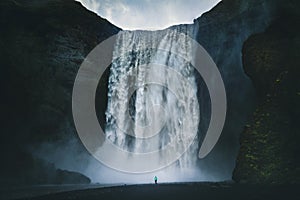 Hiker at gigantic Skogafoss waterfall in Iceland