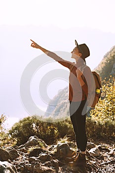 Hiker girl with backpack relaxing on top of mountain