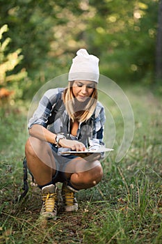 Hiker girl in a forest with a map