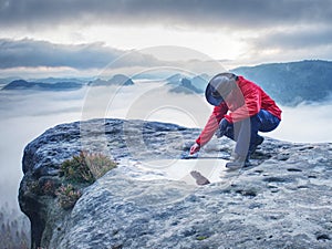 Hiker girl on mountain summit soak leaf in water eye pool