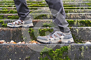 Hiker in going up the old mossy stairs