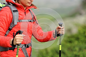 Hiker hands using poles to trek in the mountain