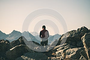 Hiker in high altitude rocky mountain landscape. Summer adventures on the Italian French Alps, toned image.