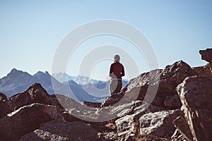 Hiker in high altitude rocky mountain landscape. Summer adventures on the Italian French Alps, toned image.