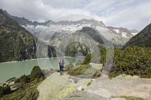 Hiker hikes through a wild high alpine landscape with a lake