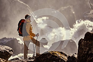 Hiker hiking with backpack looking at waterfall