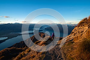 A hiker hiking on the beautiful track with a landscape of the mountains and Lake Wanaka. Roys Peak Track, South Island, New