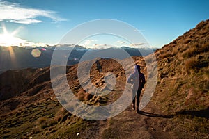 A hiker hiking on the beautiful track with a landscape of the mountains and Lake Wanaka. Roys Peak Track, South Island, New