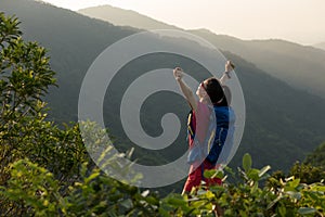 Hiker hiking on summer sunrise mountain top