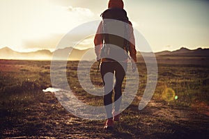 Hiker hiking on sunset mountains