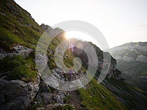 Hiker on hiking trail path along mountain cliffs in Alpstein swiss alps Appenzell Innerrhoden Switzerland