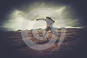 Hiker jumping across river