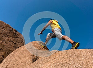 Hiker jumping over the rock